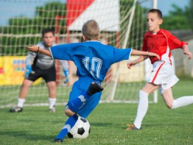 Boys kicking football on the sports field