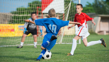 Boys kicking football on the sports field